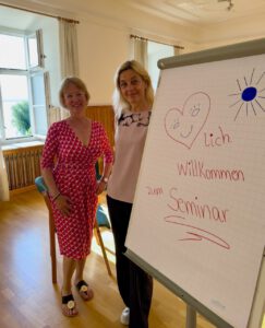 Hannelore Maurer und ich stehen neben der Pinnwand für unseren Workshop auf der Fraueninsel